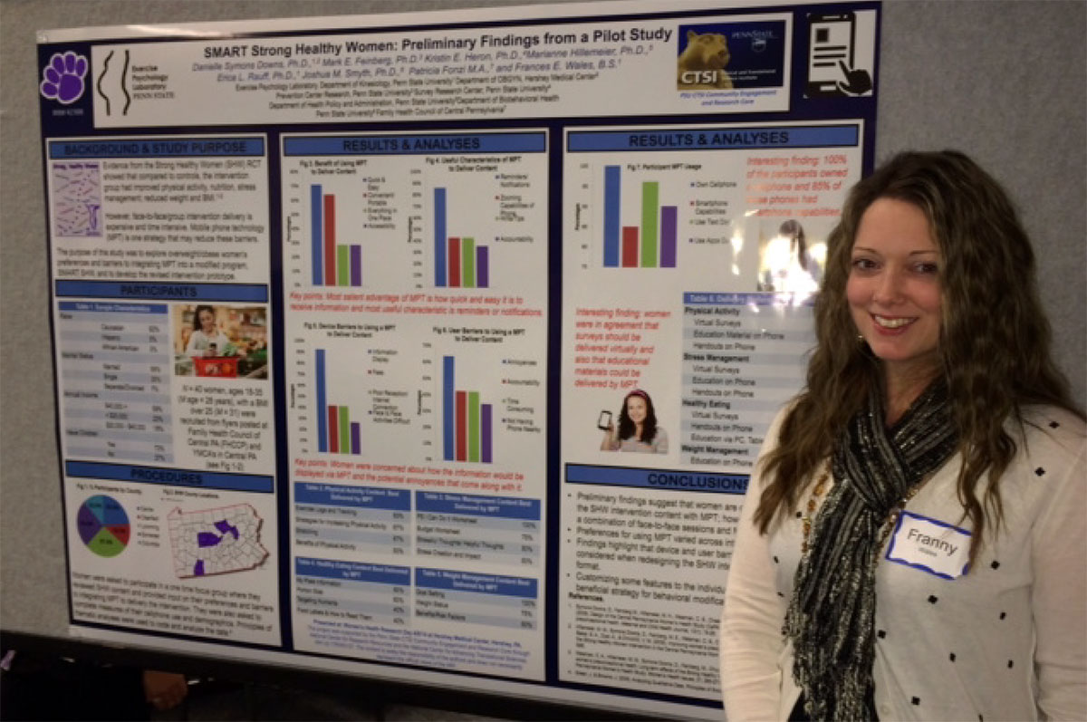 A woman stands in front of an academic poster.