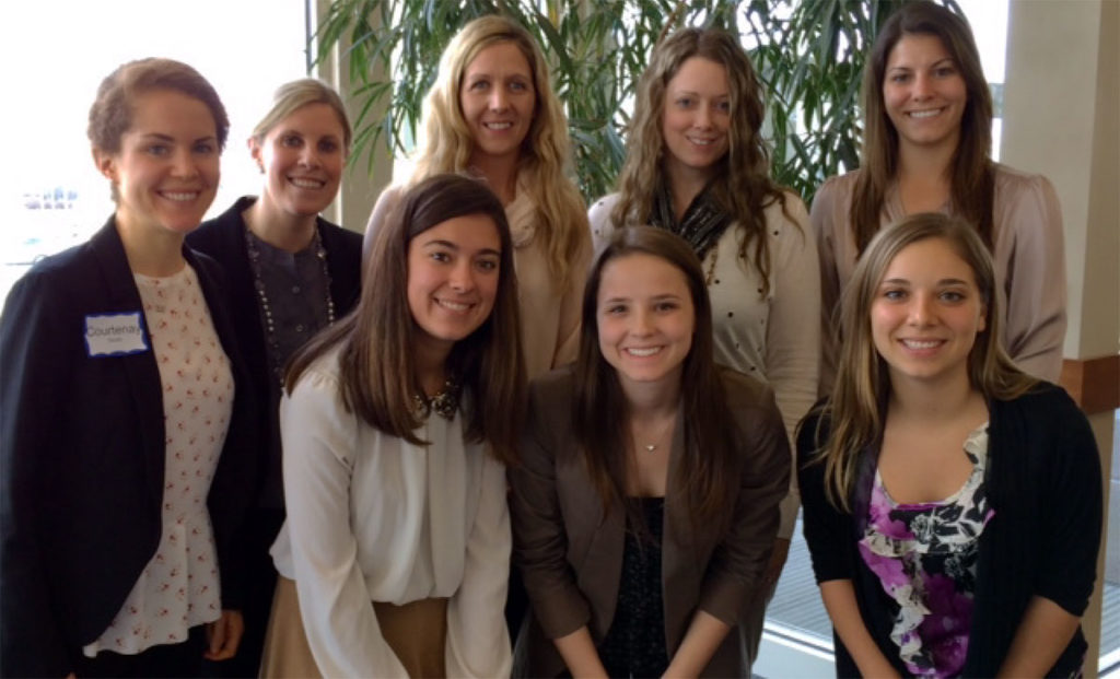 A group of eight women are pictured in two rows.