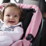 Smiling baby in sitting in a car seat