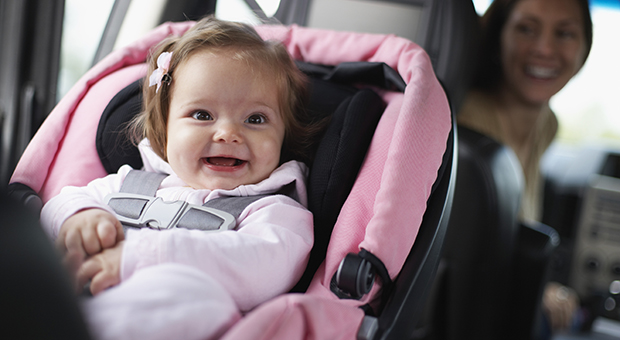 Smiling baby in sitting in a car seat