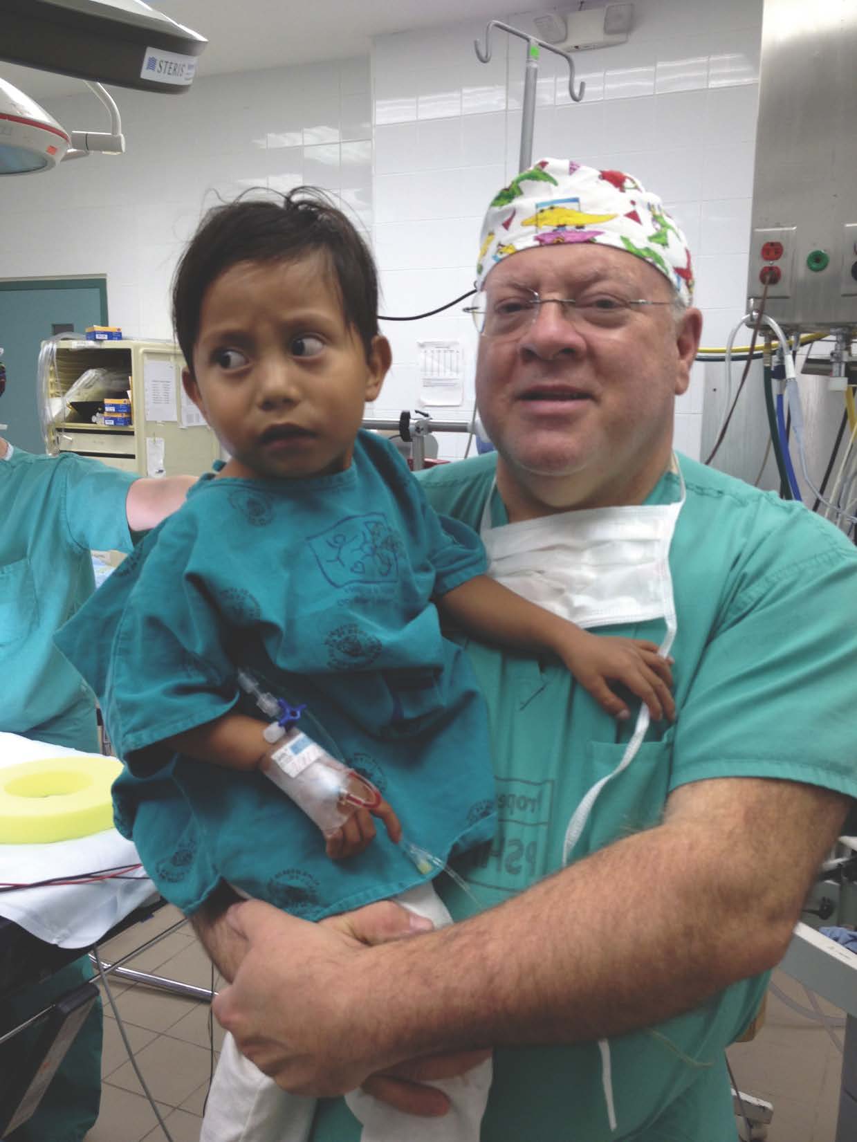 Dr. Jack Myers with a  young patient in Ecuador