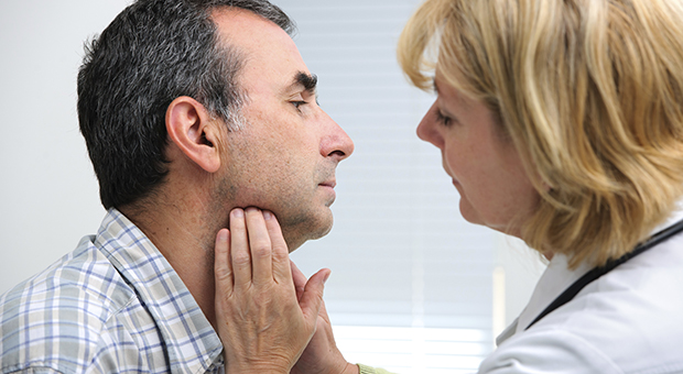 Physician examining patient's neck