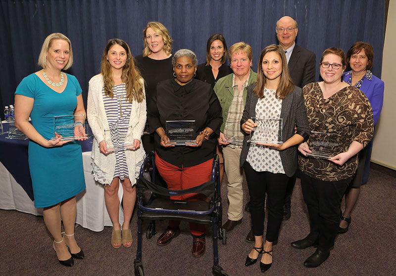 The PaTH to Health diabetes study team received the Outstanding Collaborative Research Award for 2017 at Penn State College of Medicine. Members of the study team are pictured with Dean A. Craig Hillemeier, MD (standing, second from right in back row) and Vice Dean for Research Leslie Parent, MD (standing, right in back row). The other team members are seen standing in a large lecture hall, with some holding certificates or plaques.