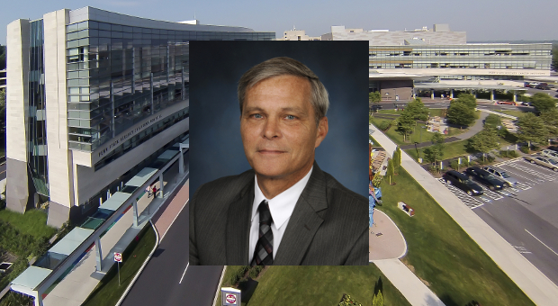 A portrait of David Smith is superimposed over a view of the Penn State Health Milton S. Hershey Medical Center and the Penn State Health Children's Hospital entrances.