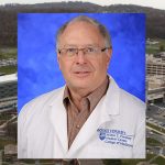 Charles Smith, PhD, recently received a one-year subaward. A photo of Smith, wearing a lab coat,, against a blue backdrop, is superimposed on top of a photo showing an aerial view of the Penn State College of Medicine campus.