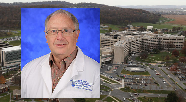 Charles Smith, PhD, recently received a one-year subaward. A photo of Smith, wearing a lab coat,, against a blue backdrop, is superimposed on top of a photo showing an aerial view of the Penn State College of Medicine campus.