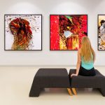 "Examine the Painting/Examine the Patient," a Humanities First Friday Lecture, shows how the art of medicine can be improved by the use of visual thinking strategies. The stock image pictured shows the back of a long-haired woman sitting on a gray bench in an art gallery, with four abstract paintings in shades of red and yellow visible on the wall in front of her.