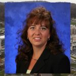 Kelly Karpa, PhD, RPh, was recently named Assistant Dean of Interprofessional Education at Penn State College of Medicine. A photo of Karpa wearing a black blazer, against a blue backdrop, is superimposed on top of a photo showing an aerial view of the Penn State College of Medicine campus.
