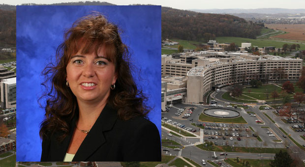 Kelly Karpa, PhD, RPh, was recently named Assistant Dean of Interprofessional Education at Penn State College of Medicine. A photo of Karpa wearing a black blazer, against a blue backdrop, is superimposed on top of a photo showing an aerial view of the Penn State College of Medicine campus.