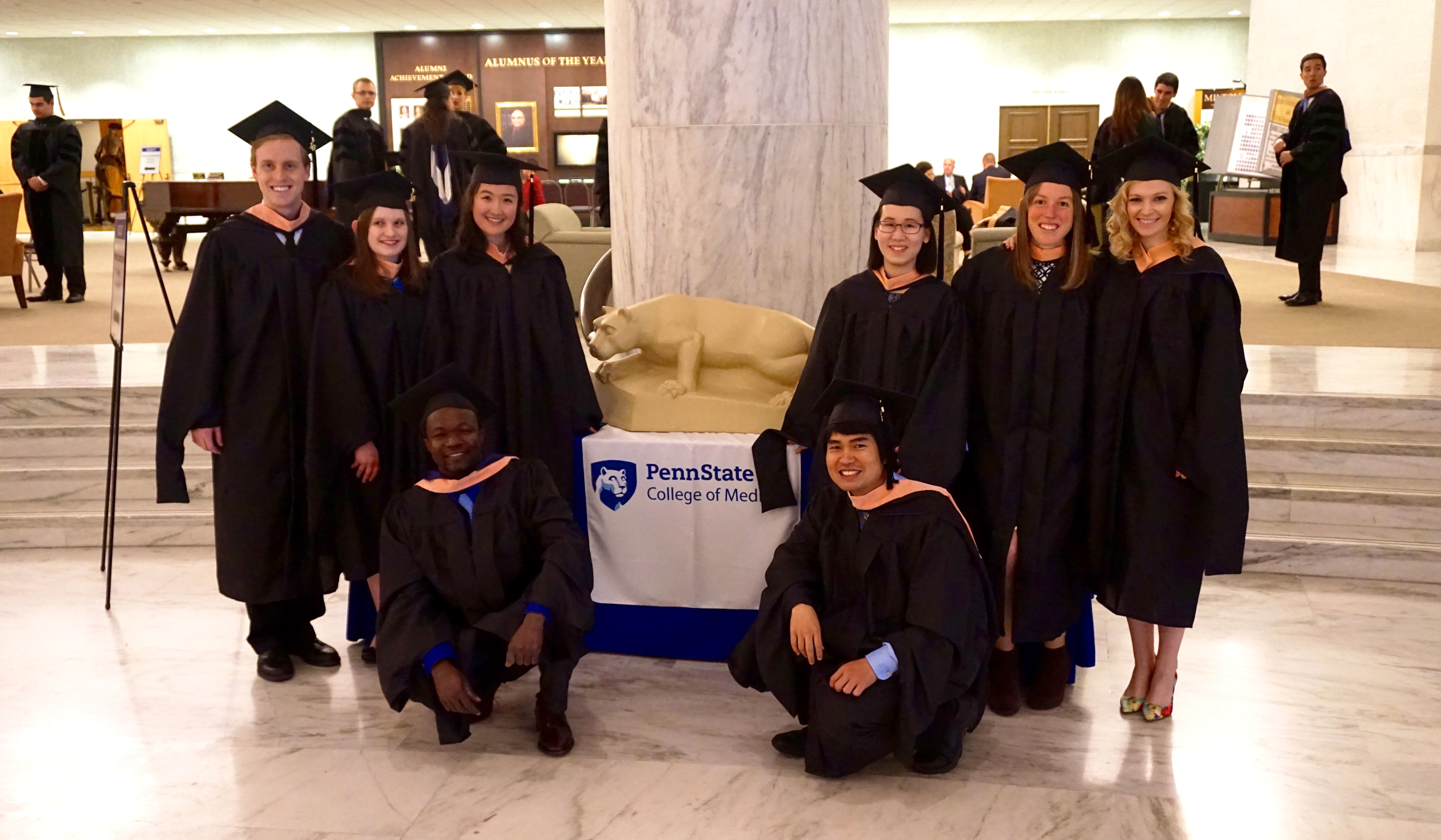 Penn State College of Medicine MPH Program graduates are seen at Graduation 2016. The students are pictured surrounding a small statue of the Penn State Nittany Lion shrine.