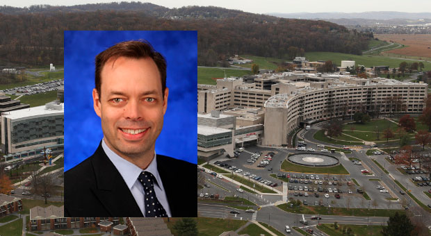 Salvatore Stella, PhD, received the 2016 Ralph Norgren Jr. Faculty Research Scholar Award at Penn State College of Medicine. Stella is pictured wearing a dark suit and tie on a blue background, and his photo is superimposed over an aerial view of Penn State's campus in Hershey, PA, with the College of Medicine Crescent building visible at right.