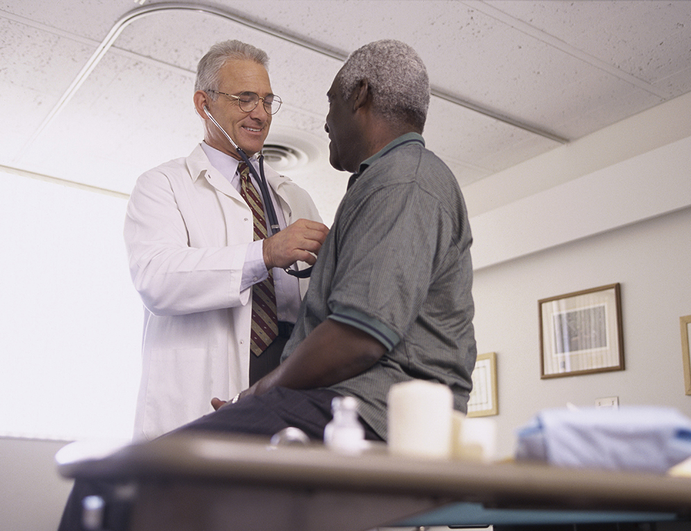 Male doctor examining a male patient.