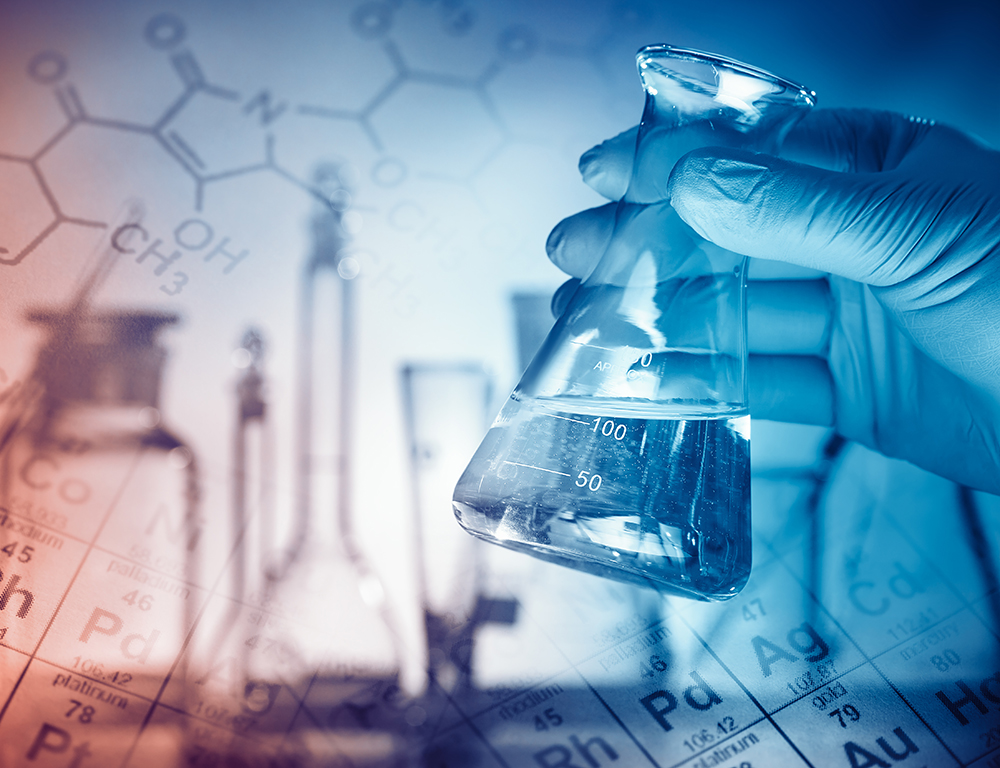 A gloved hand holds a beaker in the foreground. In the background is a periodic table with silhouette images of lab apparatus.