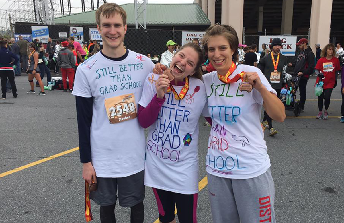 Graduate students from Penn State College of Medicine pose in their homemade T-shirts that say 'Still Better than Grad School' following the Hershey Half Marathon held Oct. 16, 2016. From left are graduate students and members of the Graduate Student Association Stephen Matthews and Nicole Hackenbrack of the biomedical sciences program and Taryn Mockus of the neuroscience program. The three students are pictured in hand-decorated T-shirts that say 'Still Better Than Grad School' and are holding or wearing race finisher medals.
