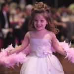 Miracle Child Leah Myers smiles while wearing a dress and dancing.