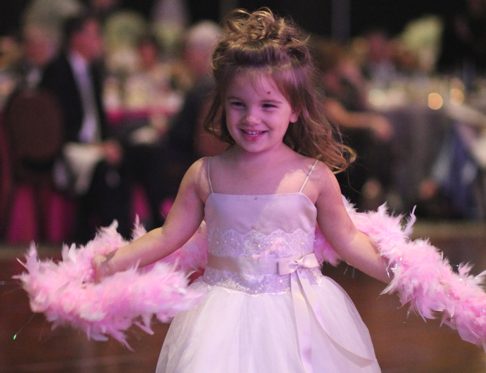 Miracle Child Leah Myers smiles while wearing a dress and dancing.