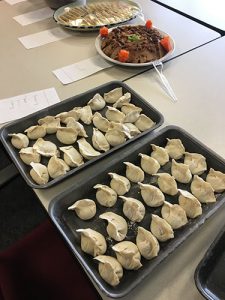 These homemade dumplings were made by Chinese colleagues in the Department of Cellular and Molecular Physiology. The photo shows two trays of dumplings on a conference table, with other food visible in the background.