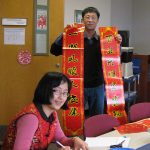 Members of Penn State College's Department of Cellular and Molecular Physiology held a celebration in honor of Chinese New Year. The holiday took place Jan. 28, 2017. Several members of the department are pictured in a conference room. One is holding a large banner with Chinese characters; others are looking at each other or the camera and smiling. Various food and other items are seen on the table in front of the group.