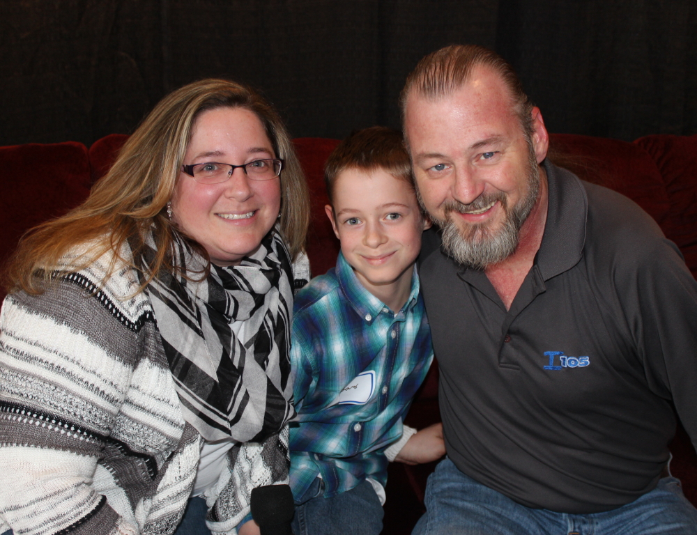 Kim Welch, Aidan Burnett and Rich Creeger pose for a photo in front of a black backdrop.