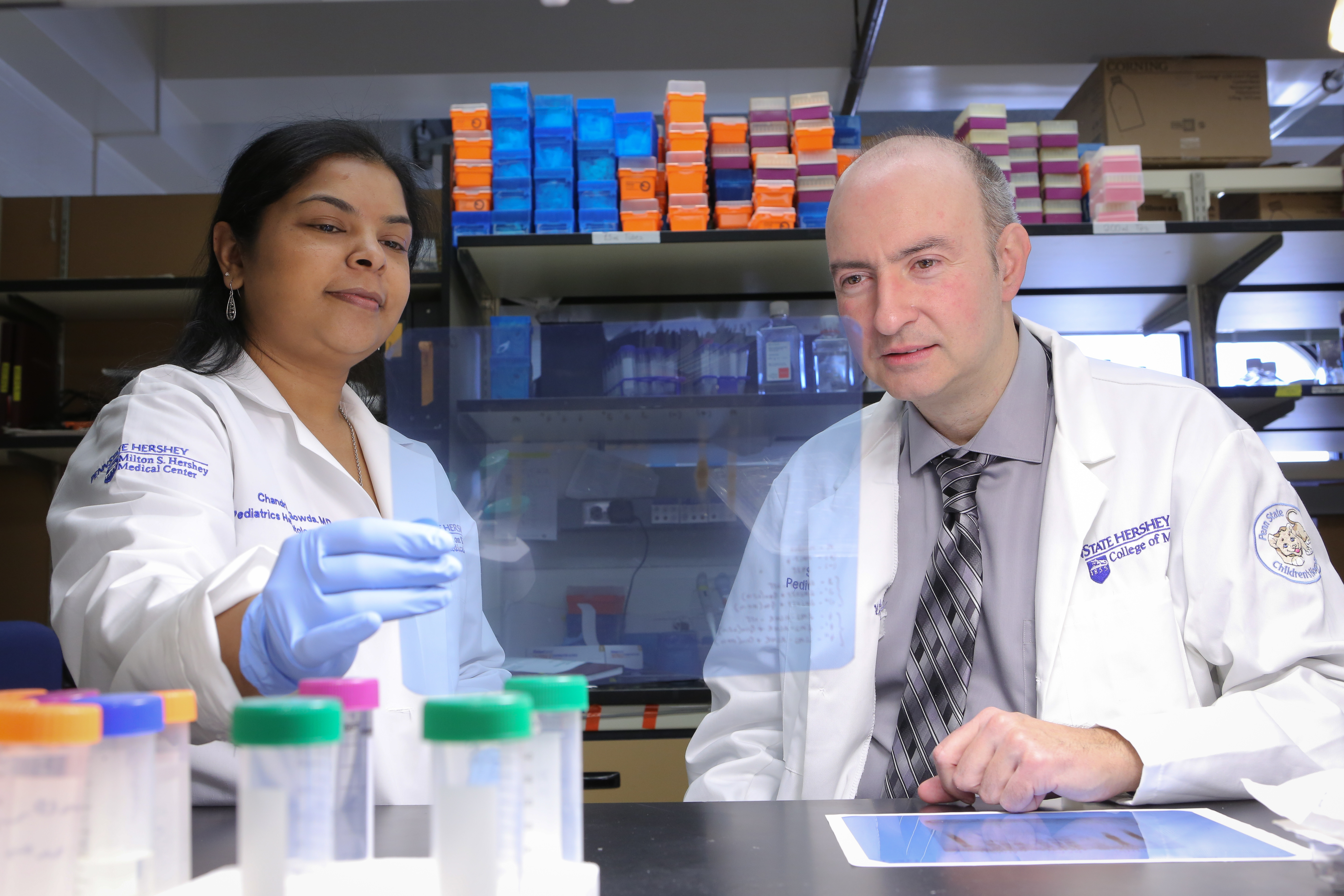 Dr. Chandrika Gowda is seen with her mentor, Dr. Sinisa Dovat. Gowda recently received a 2017 Young Investigator Award for her work in pediatric hematology/oncology. The two investigators are picture in a lab, with sample vials on the table in front of them and laboratory equipment visible in the background.