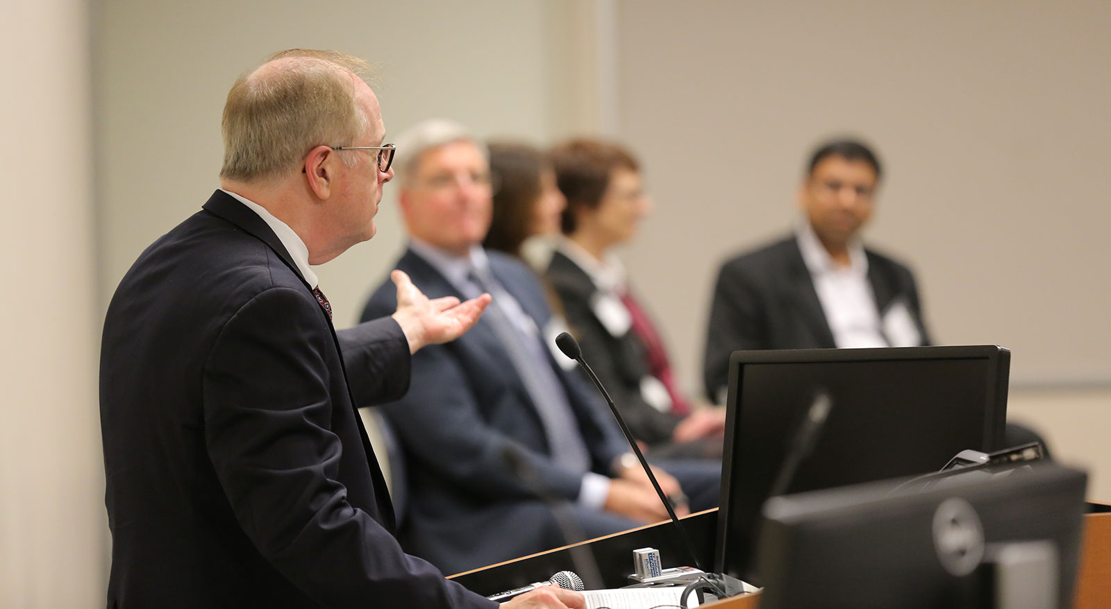 Kevin Harter of Penn State Center for Medical Innovation addresses a panel consisting of Anthony P. Bihl, Andrea Lauber, Jacquelyn Fetrow and Nishit Trivedi at the 2016 Innovation Awards ceremony. The 2017 event will be held Nov. 28. Harter is pictured at left, looking to the right of the photo with his arm outstretched toward the panel, who are pictured facing the camera and Harter.