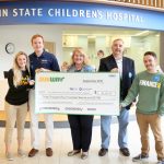 Five people pose for a photo while holding an oversized check in the amount of $30,420.52, from Subway to Four Diamonds at Penn State Children™s Hospital.