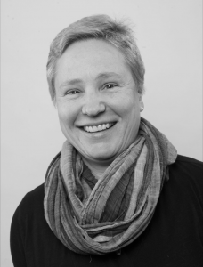 Author M.K. Czerweik is pictured wearing a scarf and dark shirt in a professional photo.