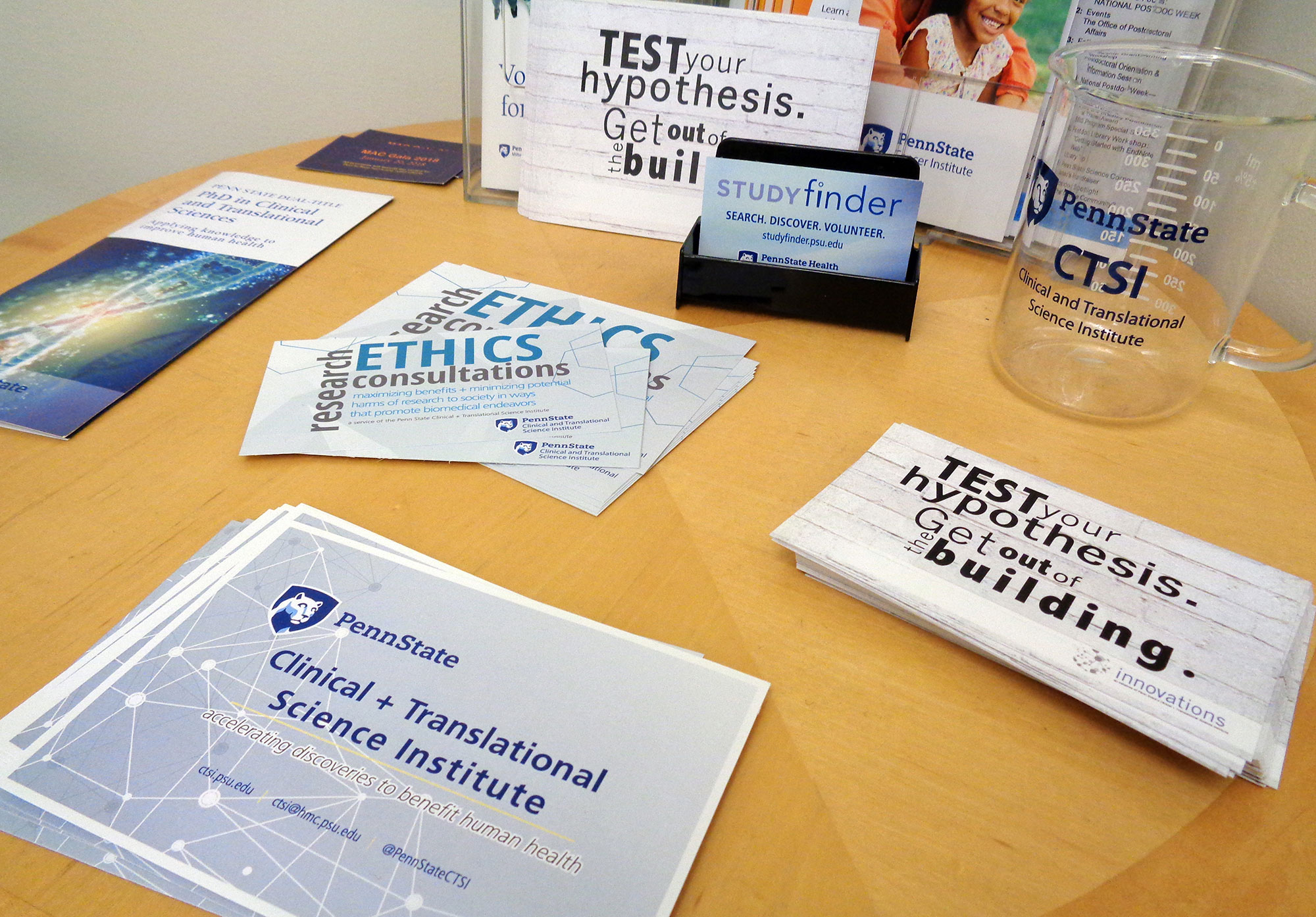 A promotional image for Penn State Clinical and Translational Science Institute shows a number of pamplets, cards and other items advertising CTSI services spread out on a table.