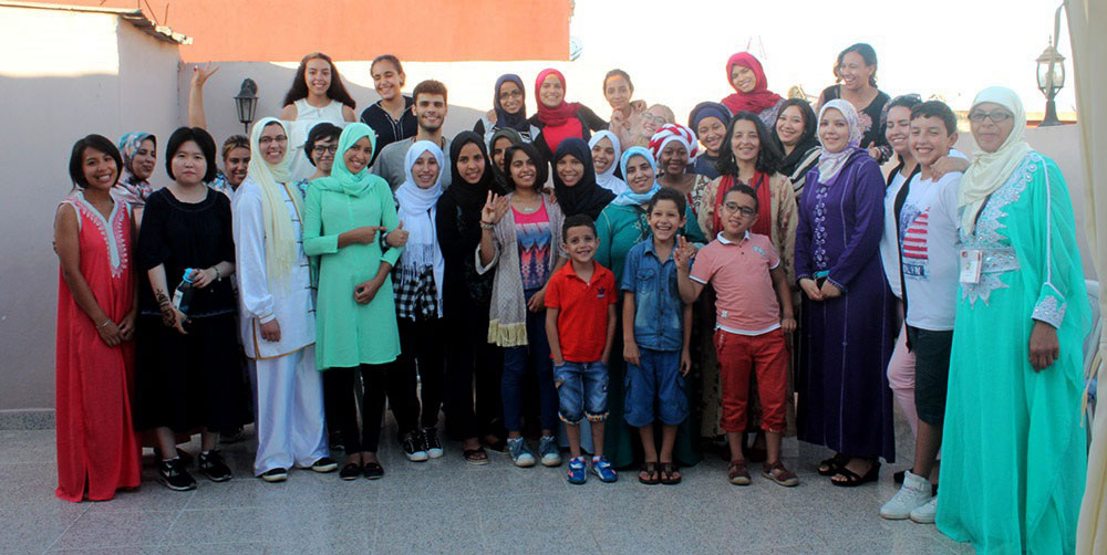 Elizabeth Krajan, a Master of Public Health candidate at Penn State College of Medicine, served as an intern with a nonprofit organization in Morocco called Maison de SantÃ© Albalsam (MSA). She is pictured at left, celebrating the end of a day-long multicultural awareness event with MSA staff, volunteers and beneficiaries in 2017. A large group of 30 or more people, mixed in age, appears with Krajan; the group is standing outdoors.