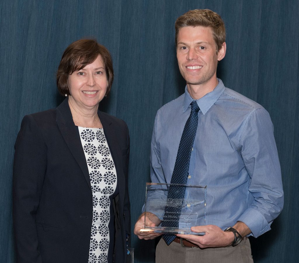 Dr. Steven Hicks is pictured standing with Dr. Leslie Parent after Hicks received one of two 2018 Distinguished Early Stage Investigator Awards, which he is holding.
