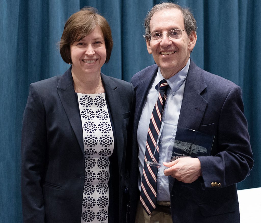 Dr. Ian Zagon is pictured standing with Dr. Leslie Parent after Zagon received the 2018 Career Research Excellence Award, which he is holding.
