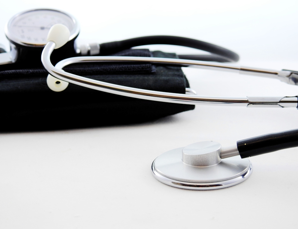Close-up of a stethoscope and a blood pressure cuff sitting on a table.