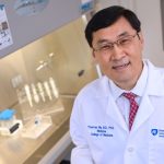 Dr. Thomas Ma aims to improve faculty work satisfaction and build a stronger research program at Penn State College of Medicine. Ma is pictured standing in a laboratory, wearing a medical coat, with lab equipment visible in the background.