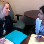 Dr. Jennifer Kraschnewski and Dr. Deepa Sekhar are pictured sitting at a table with folders open in front of them.