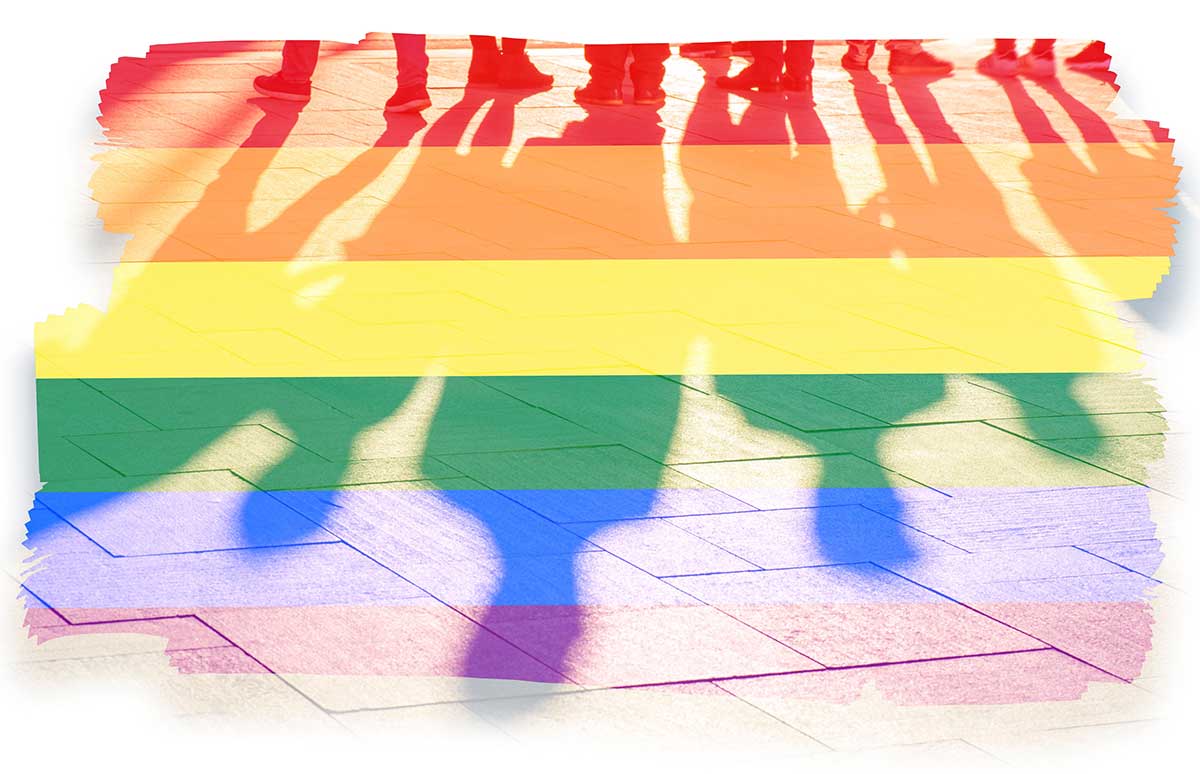 Shadows of people in rainbow colors stand on a sidewalk. Over them are rainbow stripes.