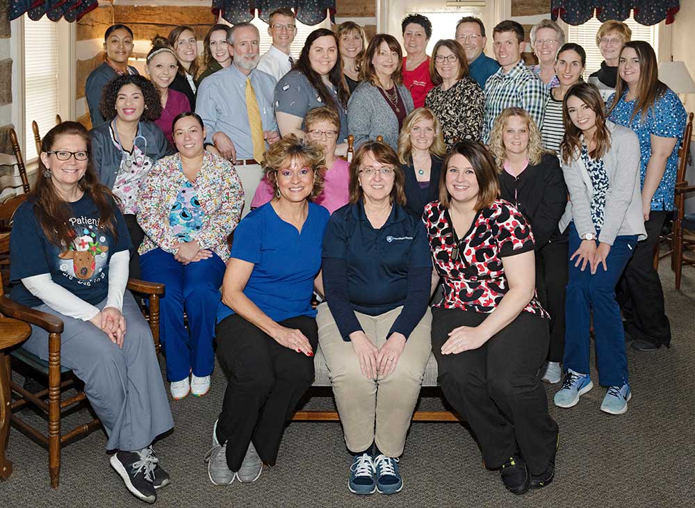 Staff and providers at Penn State Health Medical Group – Oyster Point celebrate being named Lancaster County’s No. 1 family practice by Lancaster County Magazine readers. About 30 people sit in chairs and stand, posing in the practice site’s lobby.