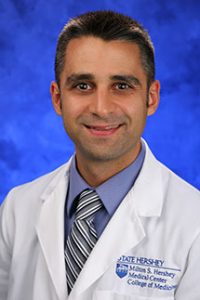 Dr. Jed Gonzalo is shown in a lab coat and a striped tie.