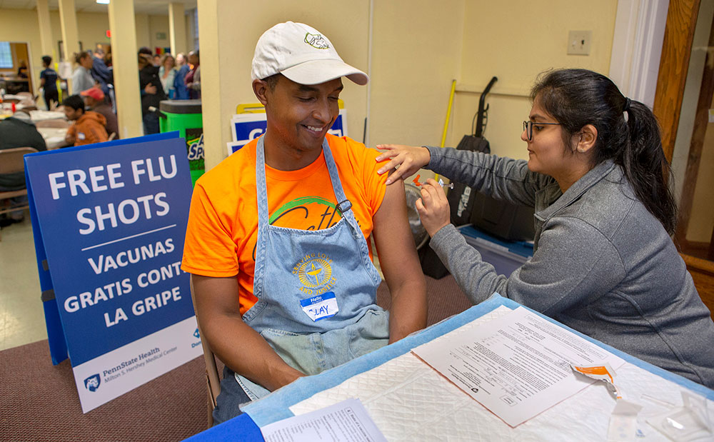 Penn State College of Medicine student Himadri Patel gives Clay Lambert a flu shot at the LionCare clinic.
