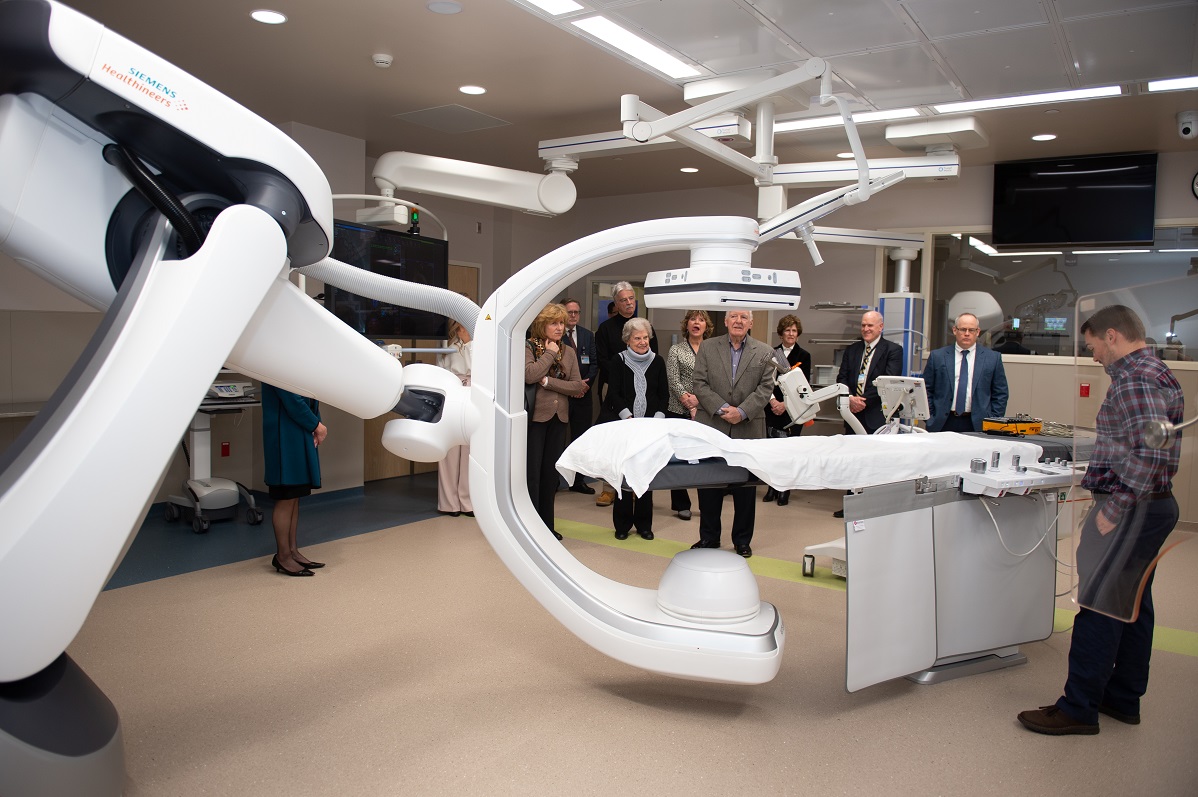 A group of people look at a large piece of medical equipment