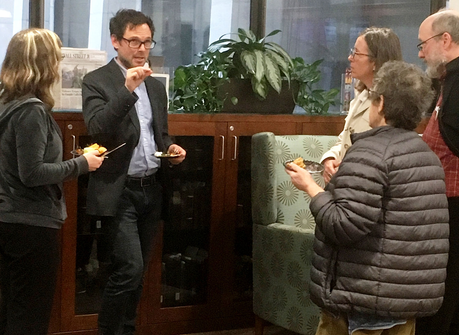 A man is seen addressing a small group of people standing around him.