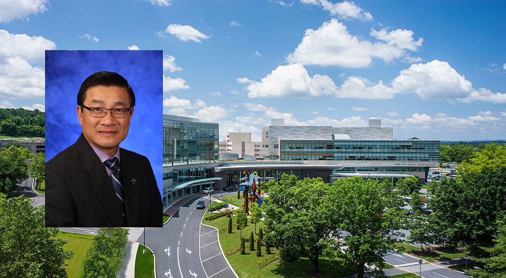 A head-and-shoulders professional photo of Duanping Liao is seen superimposed on an aerial photo of the campus of Penn State Health Milton S. Hershey Medical Center and Penn State College of Medicine in Hershey.