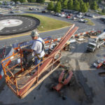 A man on construction equipment overlooks construction on the campus of a health system
