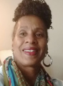 A head-and-shoulders photo shows a woman wearing a scarf and earrings and smiling.