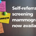 The words “Self-referral screening mammography now available” are on a woodgrain background. Next to the words are notes with messages that say “- Kids to school” “-mom to doctor” and “mammogram.