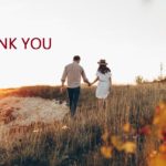 Couple holding hands walking through a fall landscape at sunset; Thank you lettering at top.