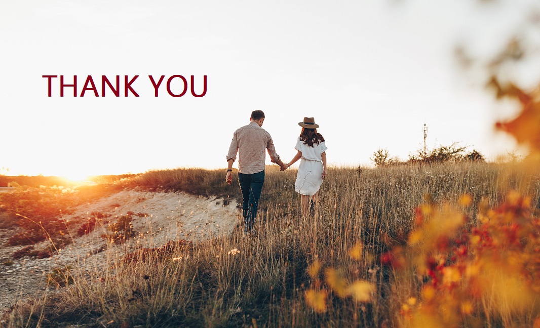 Couple holding hands walking through a fall landscape at sunset; Thank you lettering at top.