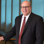 CEO Steve Massini smiles while standing at a railing for a portrait.