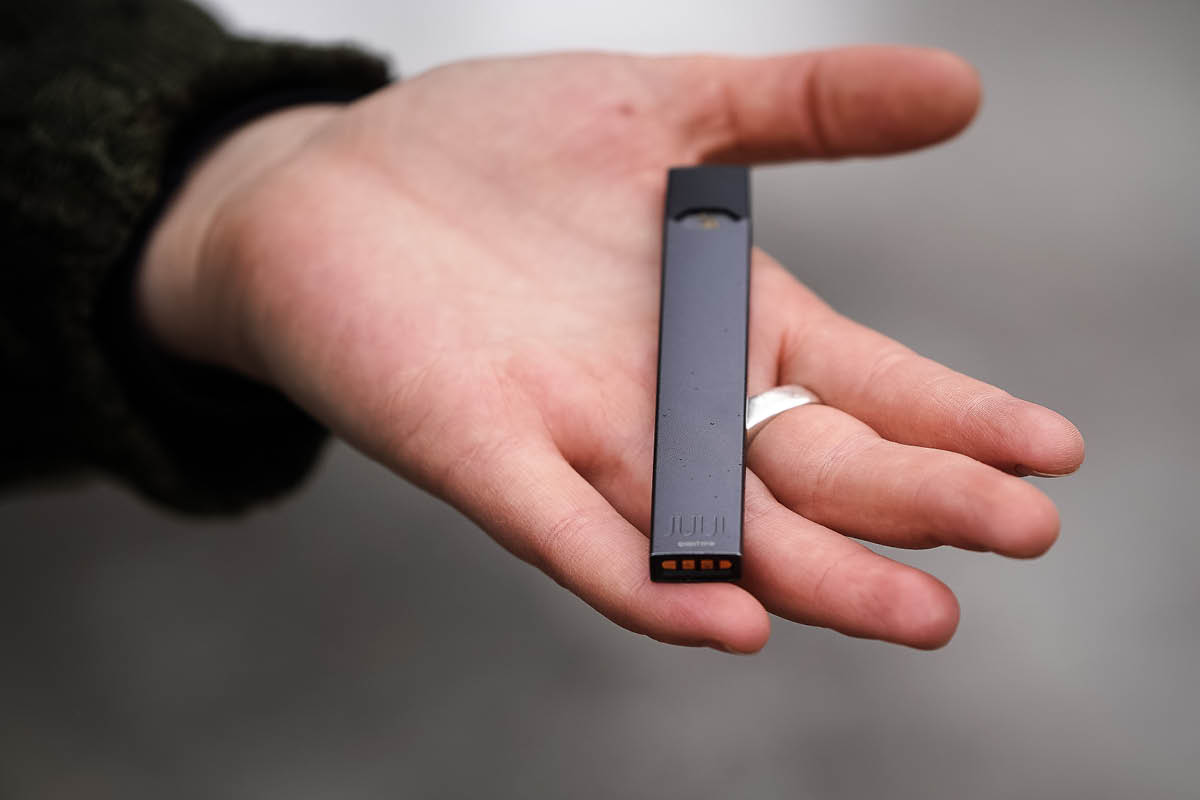 A hand holds an electronic cigarette