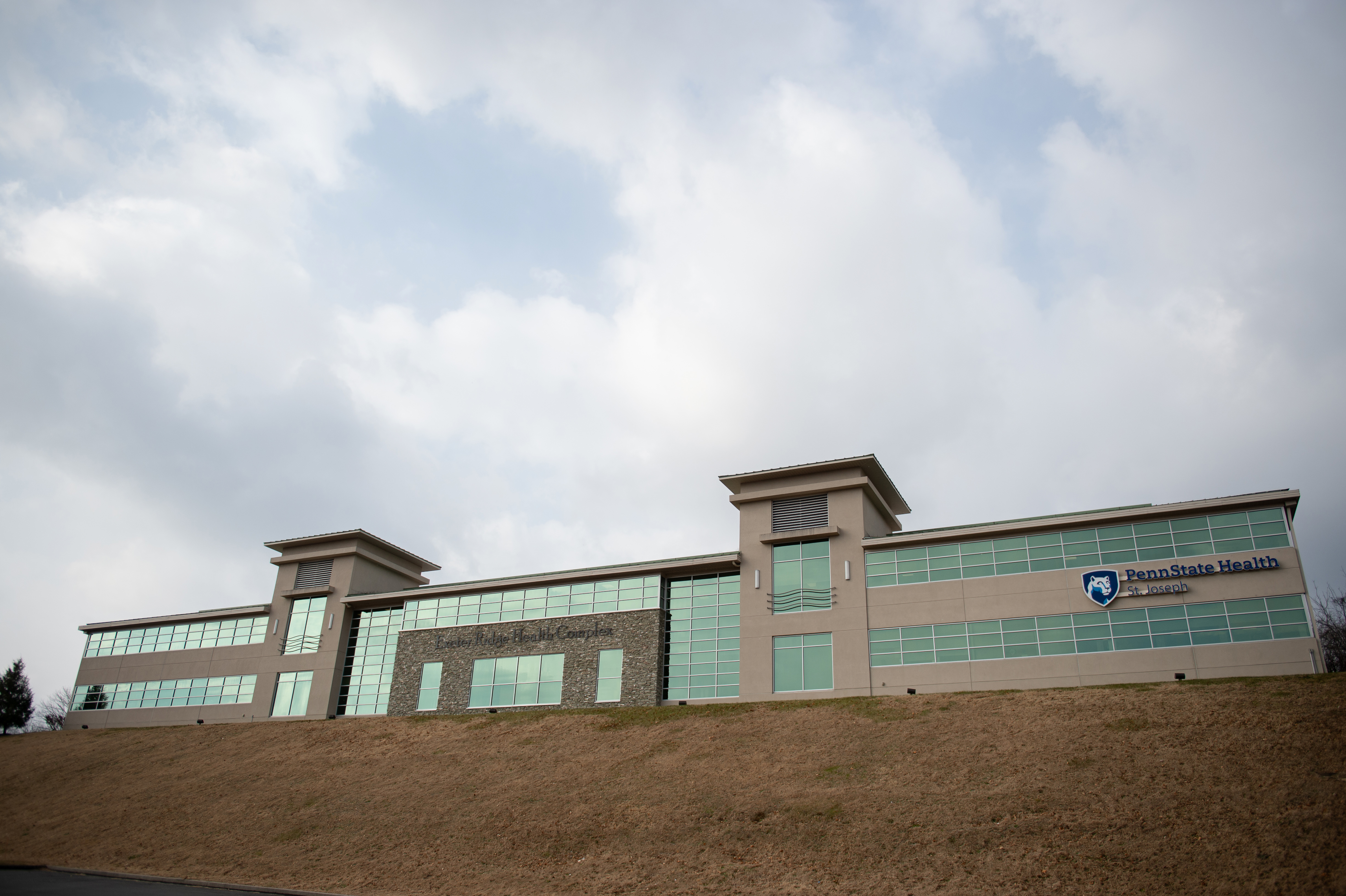 A view of the concrete, brick and glass Penn State Health St. Joseph Exeter Ridge Health Complex is shown.