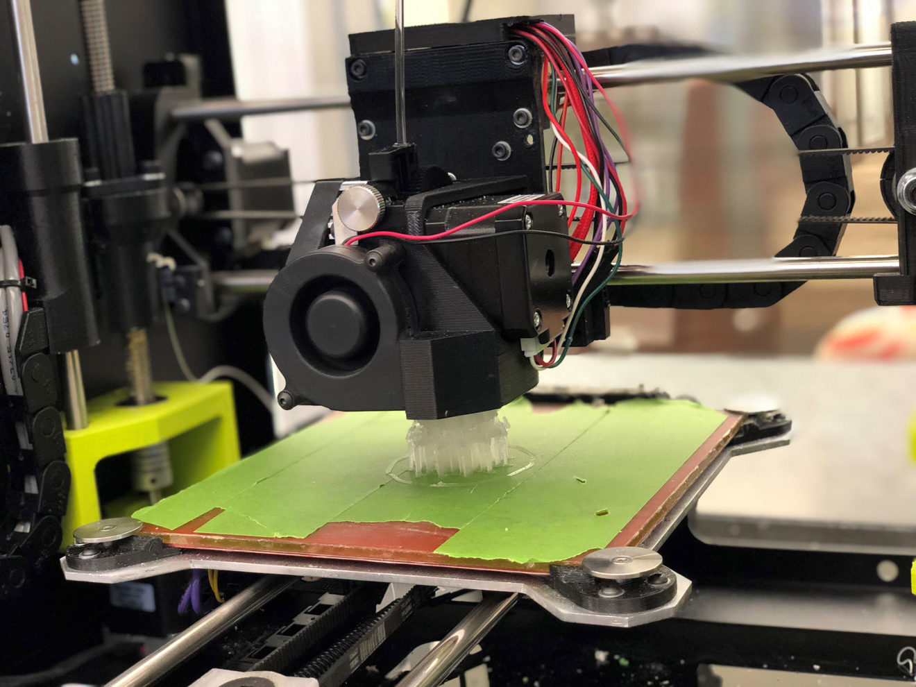 A 3D printer is seen creating a prototype out of moldable material.